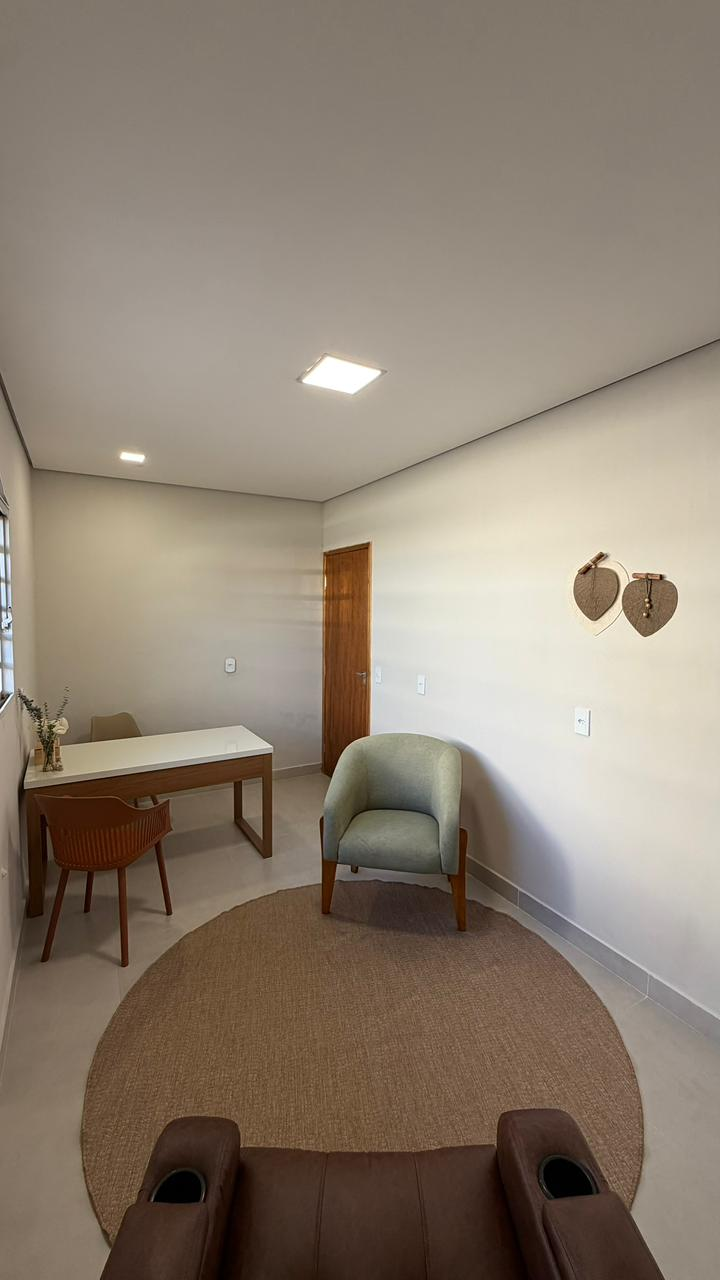 Sala 5 com mesa de trabalho, poltrona verde e decoração acolhedora